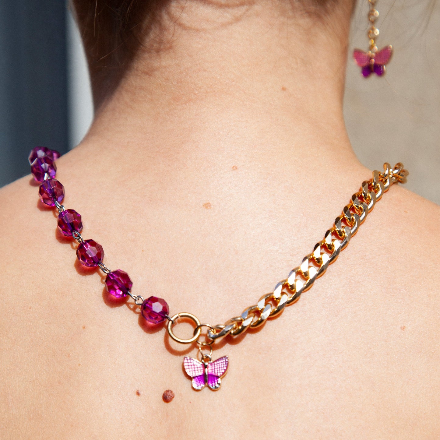 Collier upcyclé asymétrique chaine dorée perles violettes pendentif papillon